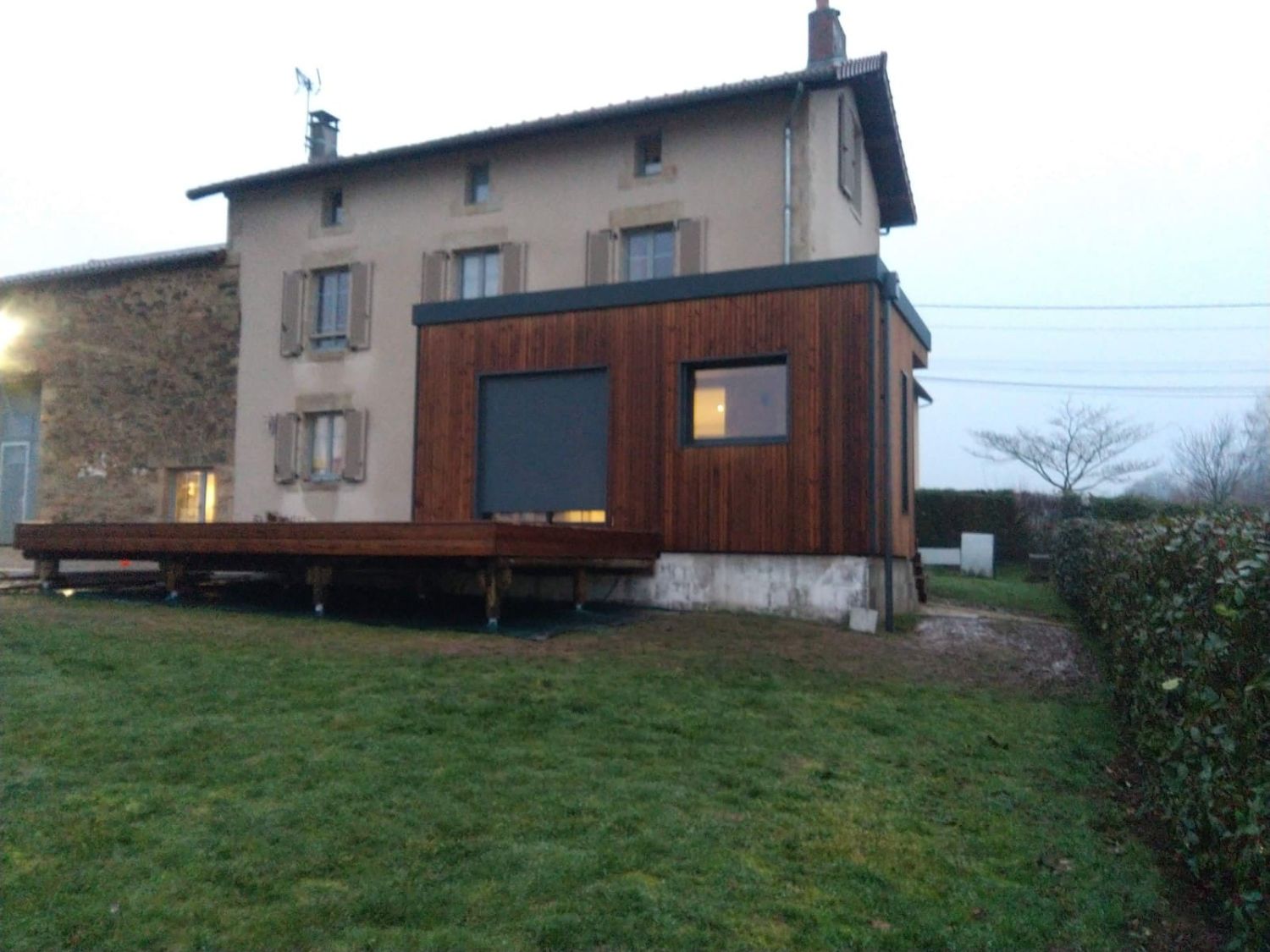 Extension en bois accolée à une maison en pierre